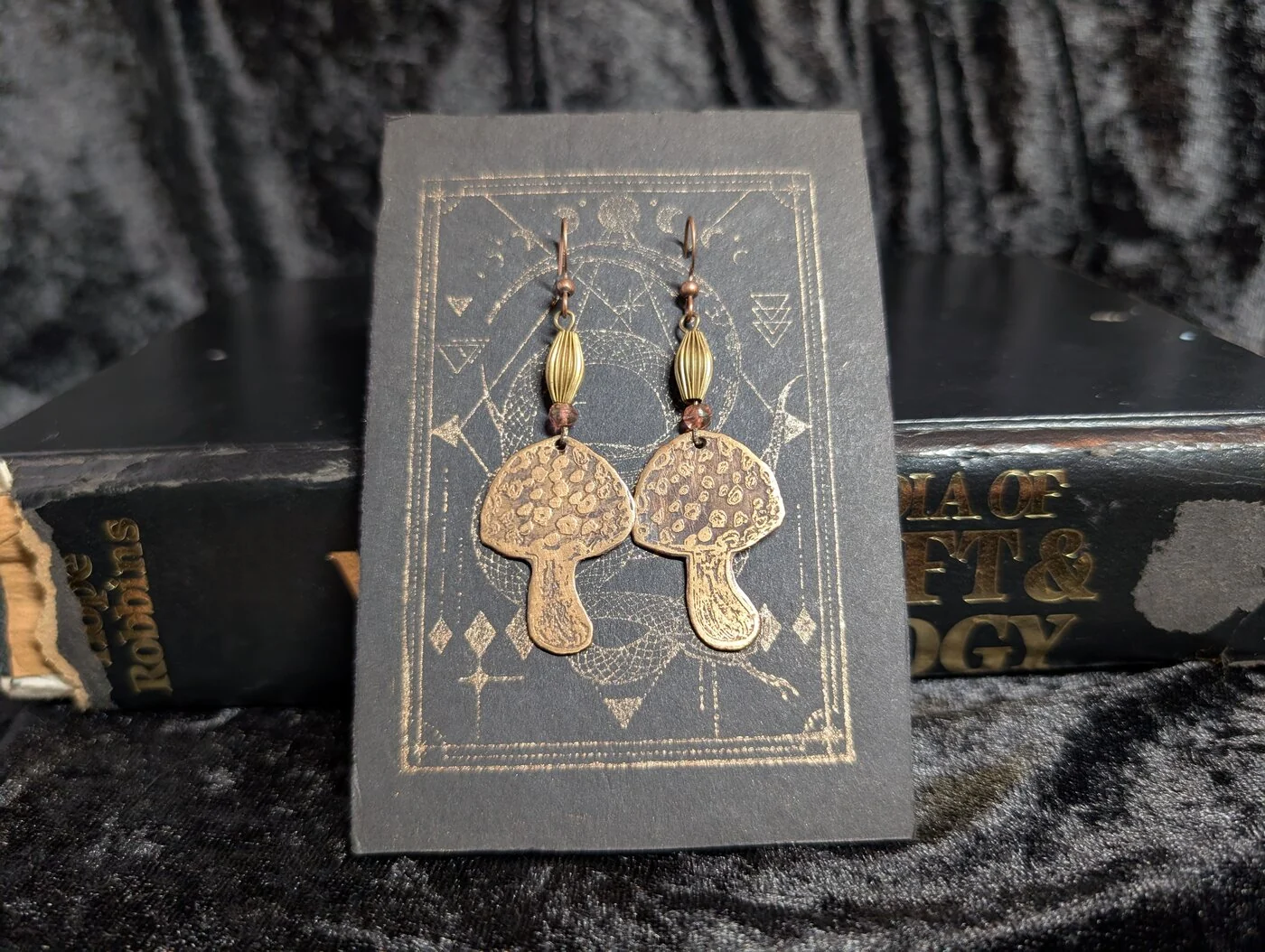 Etched bronze amanita mushroom earrings on display card by BorboroForge